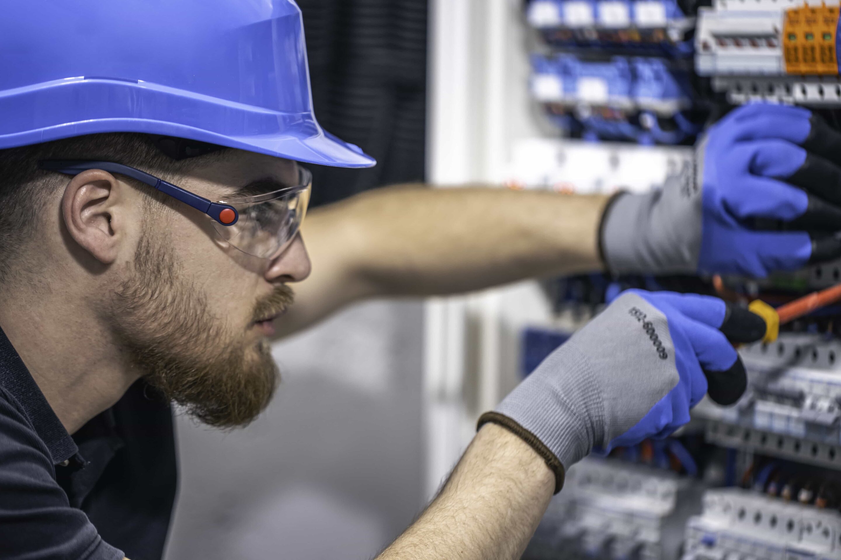 a-male-electrician-works-in-a-switchboard-with-an-2025-03-15-03-25-47-utc